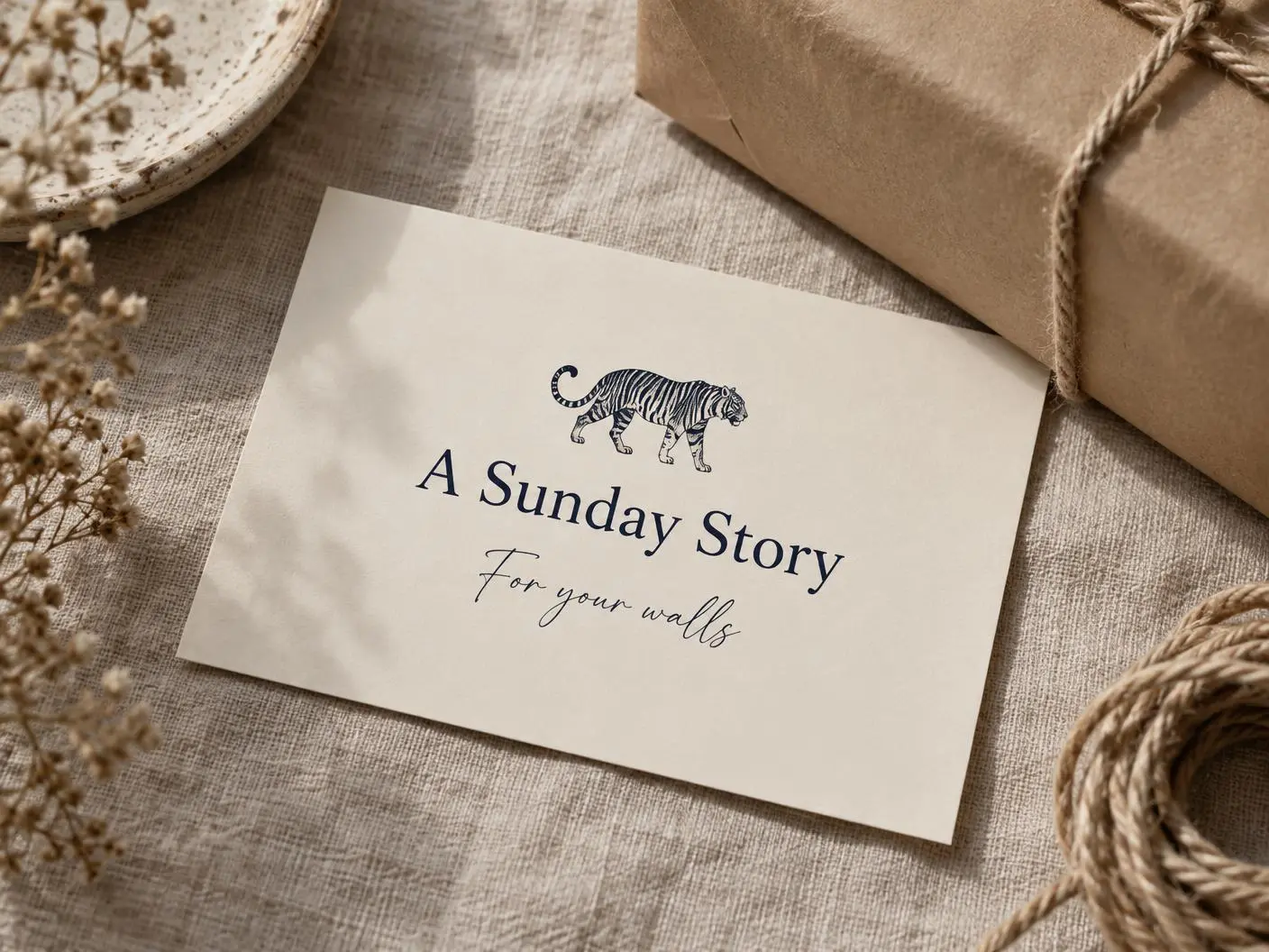 A cream A Sunday Story gift card with the tiger, resting beside kraft paper and rope wrapping